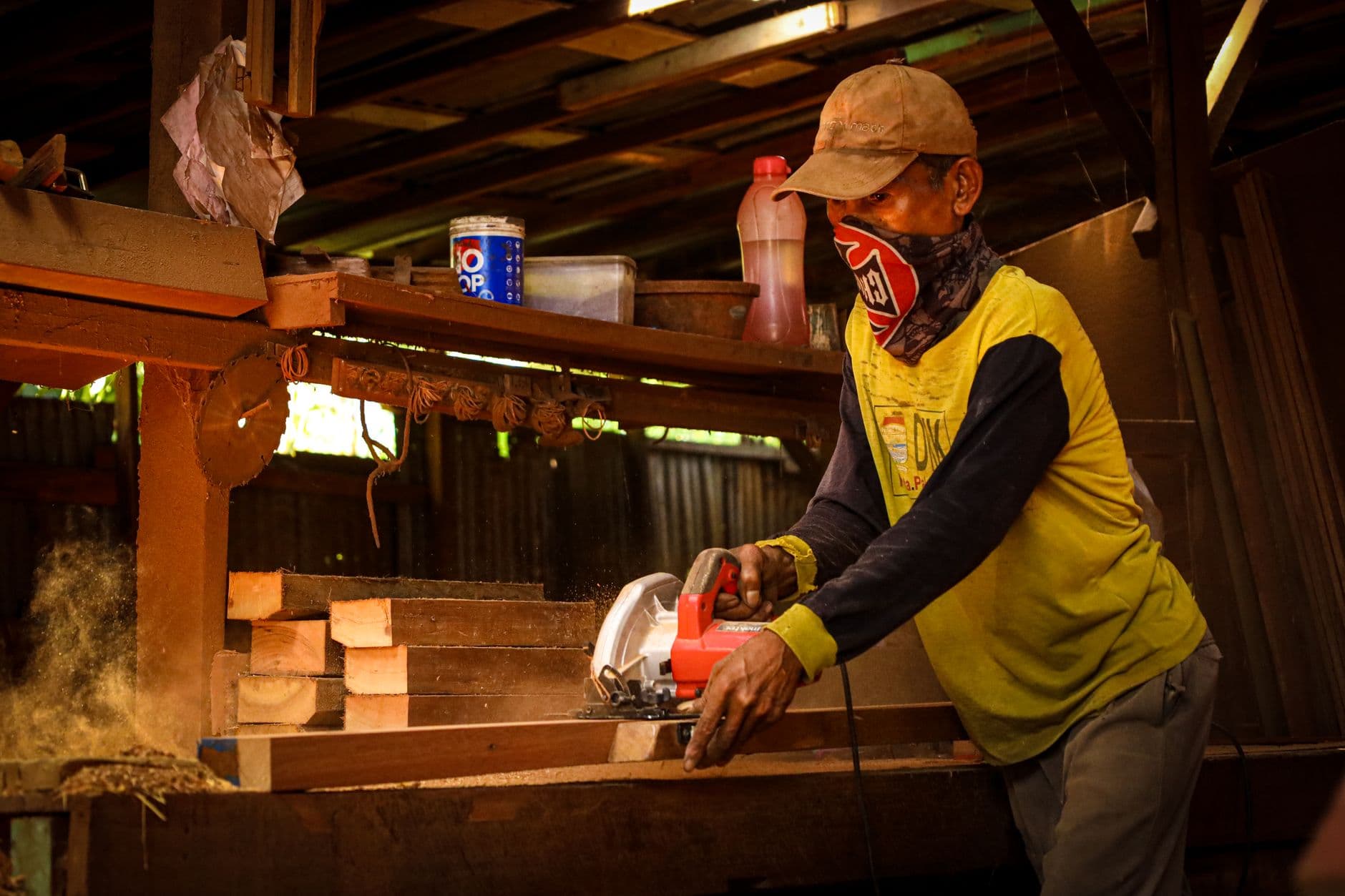 A carpenter using a circular saw in a workshop